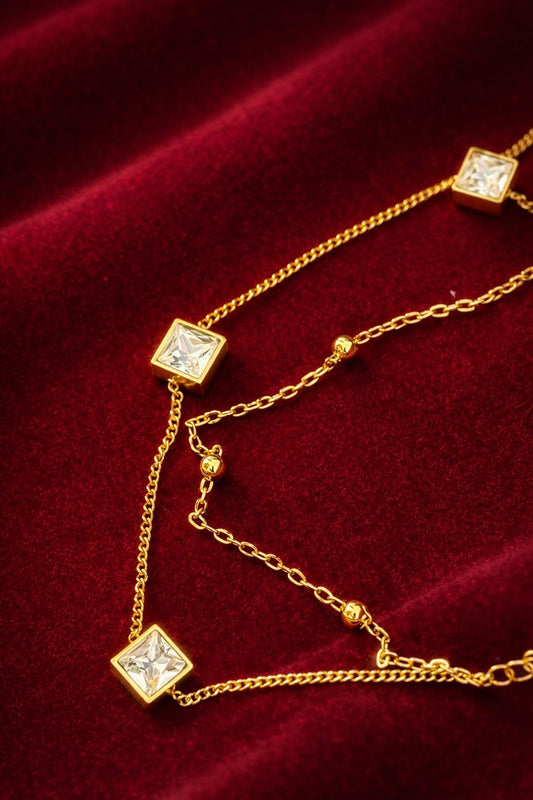 Gold layered bracelet with square crystal charms worn on the wrist