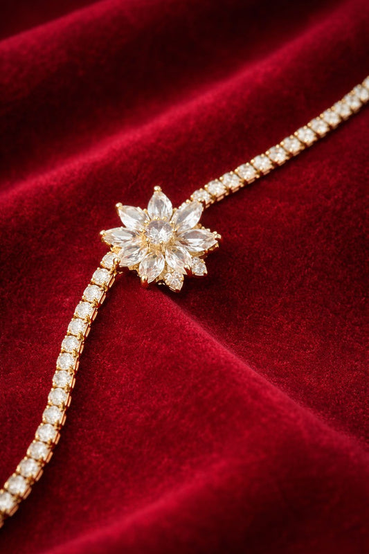“Gold bracelet with flower-shaped crystal centerpiece placed on deep red velvet fabric.”