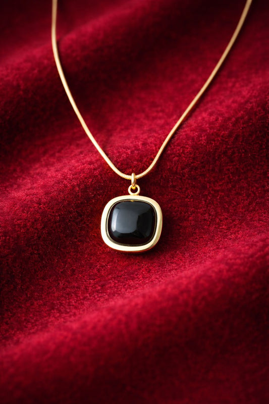 Gold-tone necklace with black  white orange stone pendant